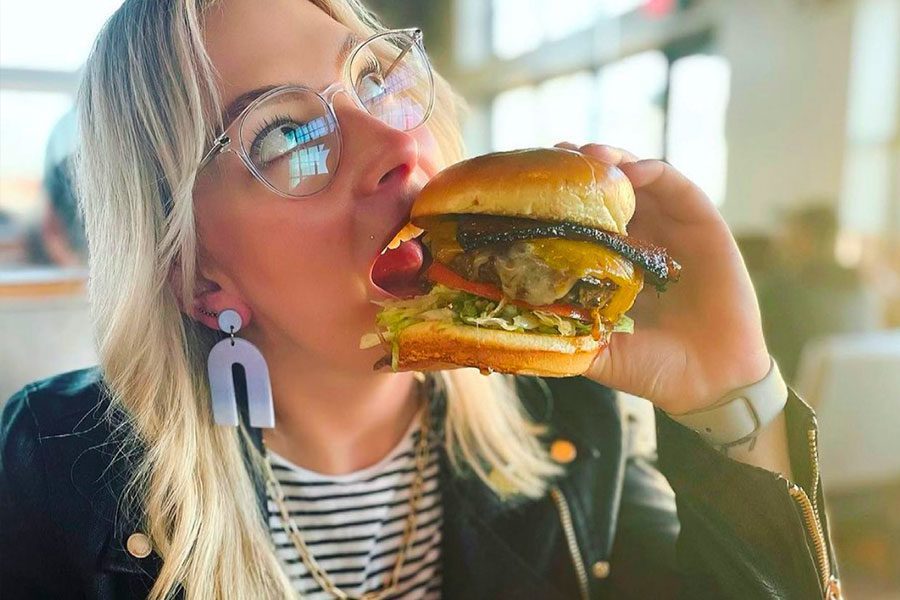 Woman eating large hamburger